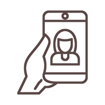 An outline of a person's hand holding a phone with a woman on the screen